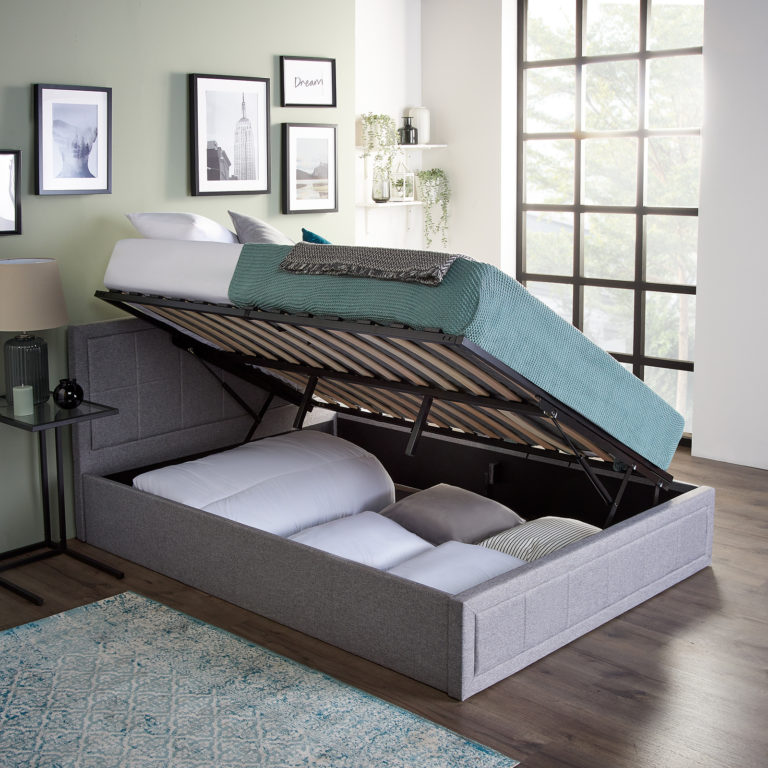 An ottoman bed with a side lifting mechanism displaying storage space underneath.