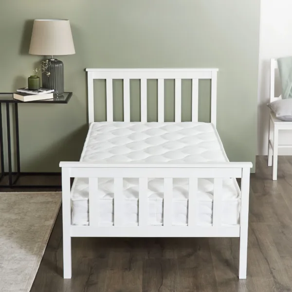 White wooden bed with sprung bonnell mattress