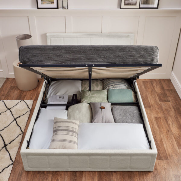 A neatly organised storage area of a white ottoman bed.