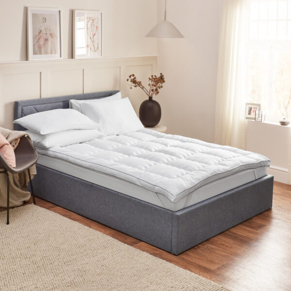 Mattress topper protector on bed frame with pillows